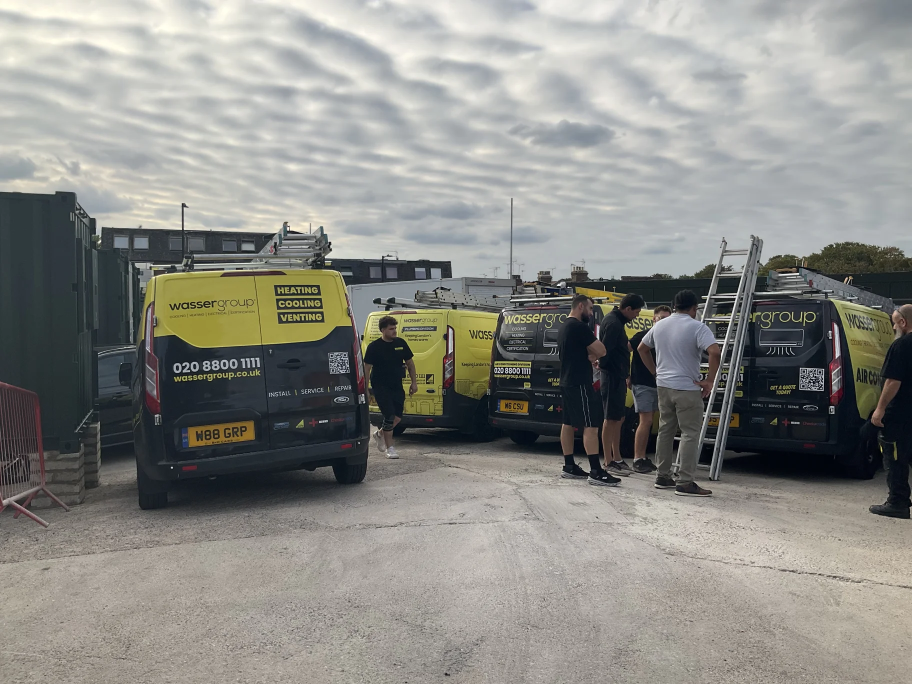 Wasser Group team beside the branded service vans
